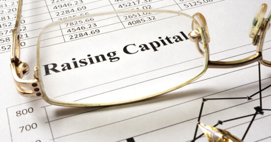 Sign raising capital on a paper and glasses.