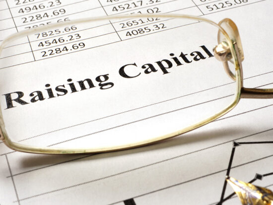 Sign raising capital on a paper and glasses.
